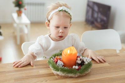 Deaf girl looking at tealight candle on table