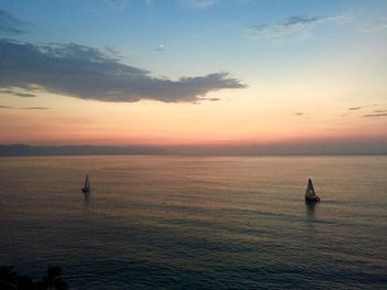 Silhouette of boat in sea at sunset