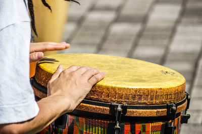 Midsection of man playing drum