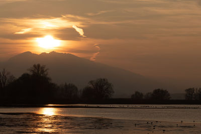 Scenic view of lake against sky during sunset