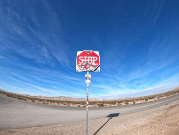 Information sign on road against sky