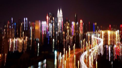 Illuminated cityscape against sky at night