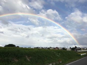 Scenic view of rainbow over land against sky
