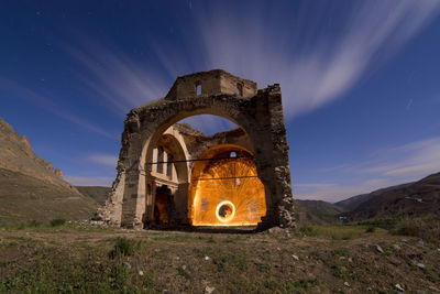 Old ruin on field against sky at night