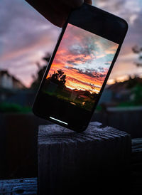 Close-up of wine glass on table against sunset sky