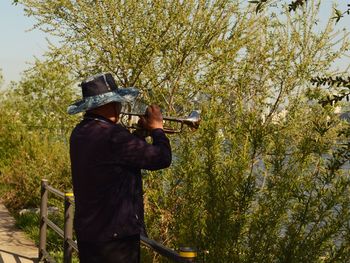 Man photographing against plants and trees