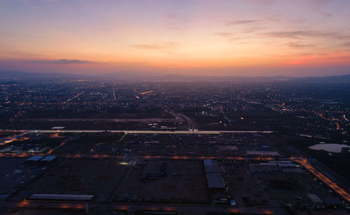 Aerial view of buildings in city at sunset