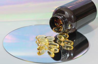 Fish oil capsules on a mirror. a bottle with omega 3 oil for heart and vessels health. 