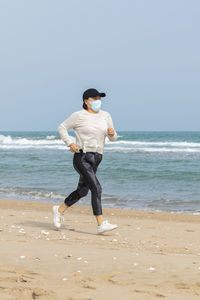 Full length of man on beach against sky