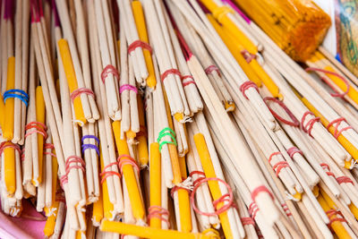 Close-up of candles and incense sticks for sale at market stall