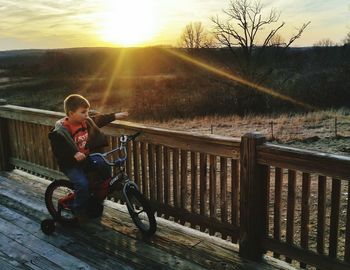 Young woman riding bicycle on railing