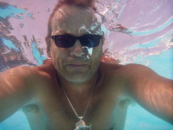 Portrait of young man swimming in pool