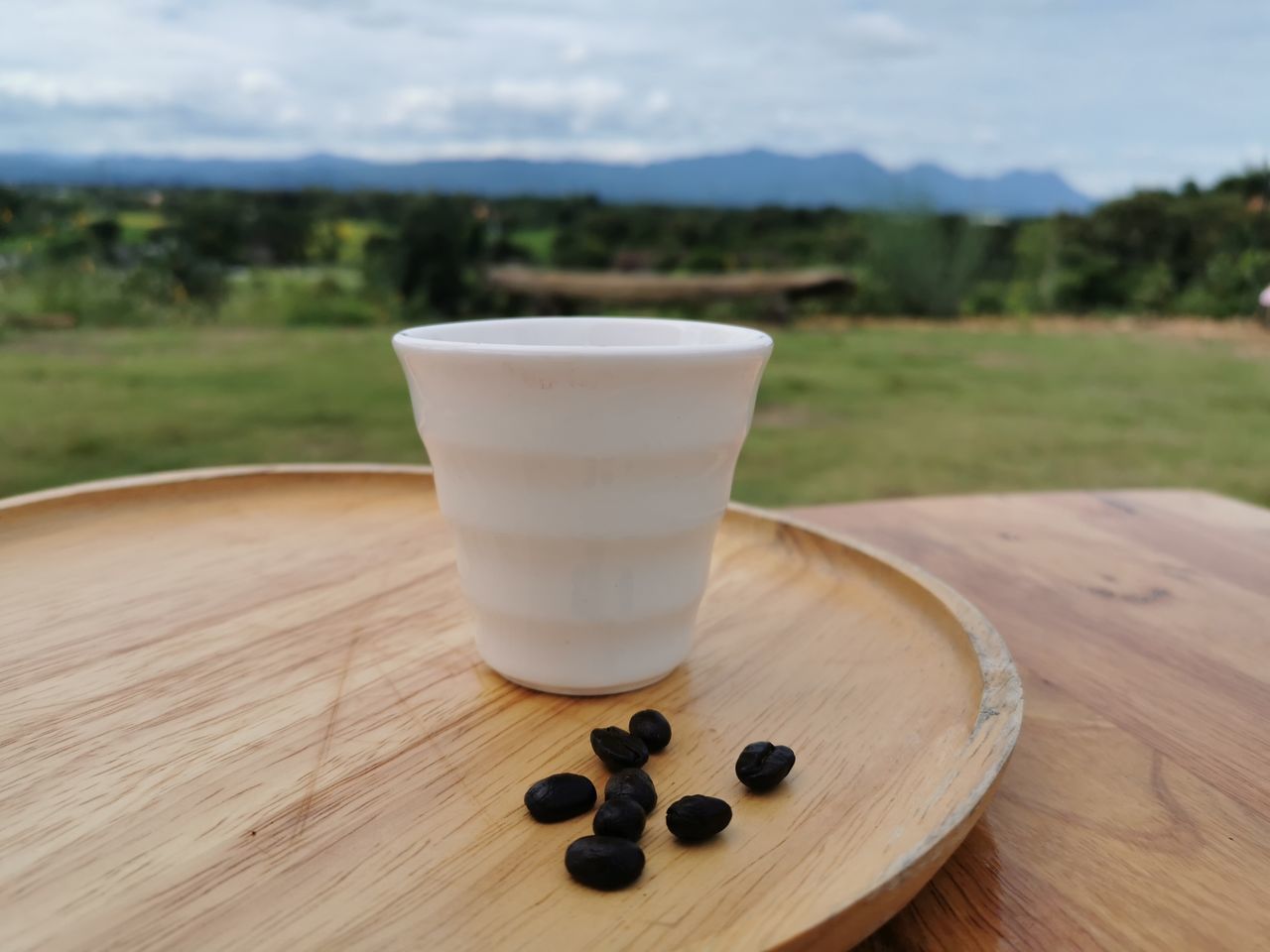 CLOSE-UP OF COFFEE CUP ON WOODEN TABLE