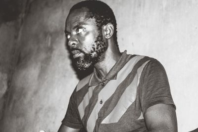 Man looking away while standing against wall