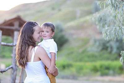 Side view of mother and daughter outdoors