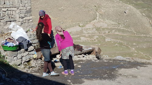 Rear view of people standing against wall