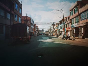 City street by buildings against sky