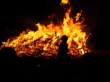 Silhouette people against fire at night