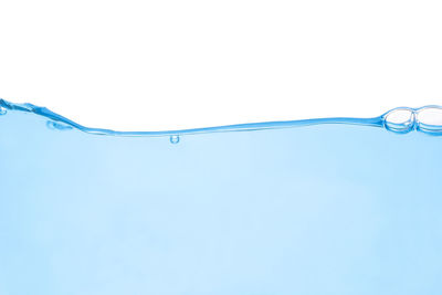 Close-up of water drops on glass against white background