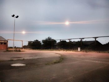 Empty road against sky during sunset