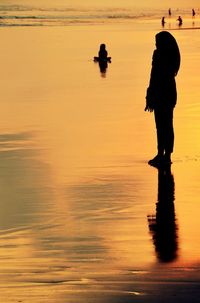 Silhouette of man in sea at sunset
