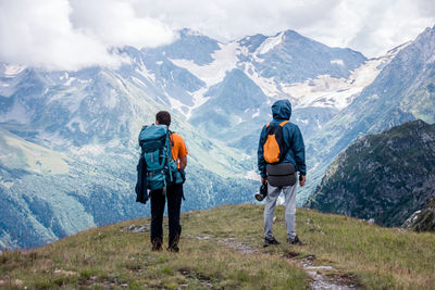 Rear view of man looking at mountains against sky