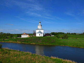 Church by building against blue sky