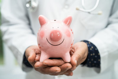Midsection of woman holding piggy bank