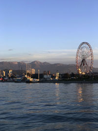 Ferris wheel at amusement park against blue sky