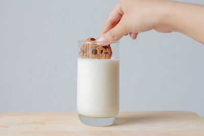 Close-up of hand holding drink on table