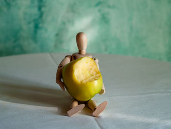 Close-up of apple on table against wall