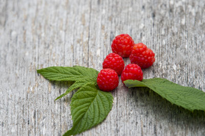 Close-up of raspberries and leaves on wooden table