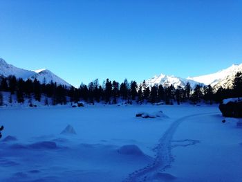 Scenic view of snowcapped mountains against blue sky