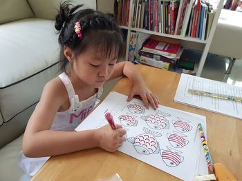 Full length of woman reading book on table