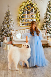 Nice girl in a light blue dress with white samoyed dog