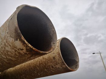 Low angle view of old pipe against sky