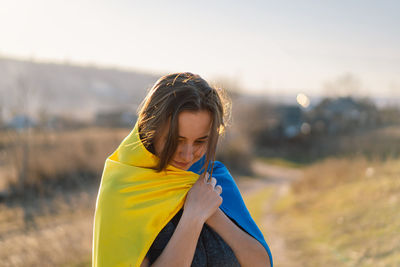 Woman holding a yellow and blue flag of ukraine in outdoors
