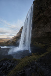 Scenic view of waterfall against sky