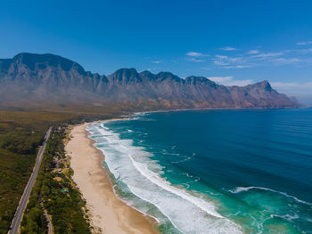 Scenic view of sea and mountains against sky