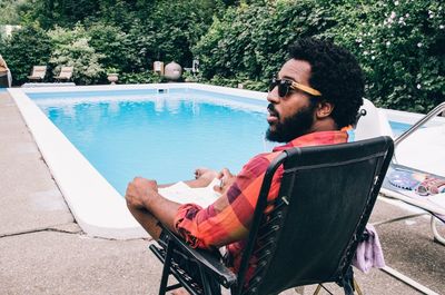 Man relaxing by swimming pool