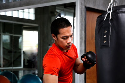 Young man practicing boxing in gym