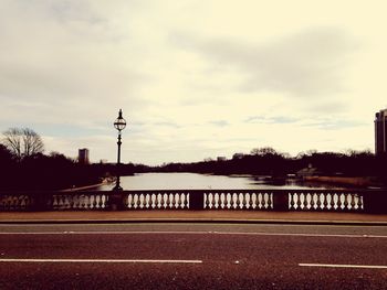 Bridge over river against cloudy sky