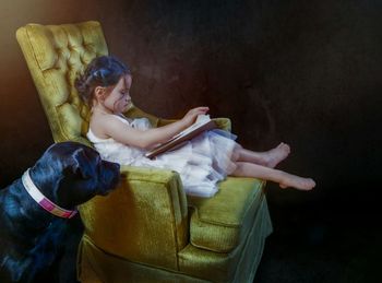 Woman holding dog sitting at home