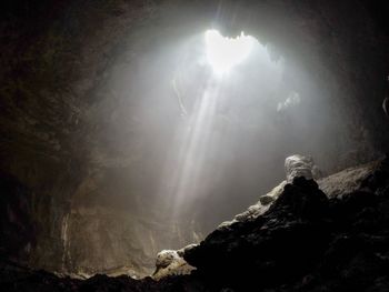 Low angle view of sunlight streaming through rocks