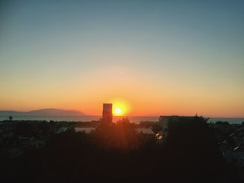 Sun shining through city at sunset