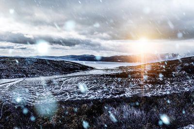 Scenic view of snow covered land against sky