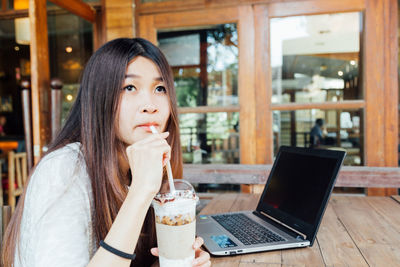 Portrait of mid adult man using mobile phone in cafe