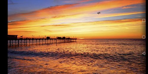 Scenic view of sea against orange sky