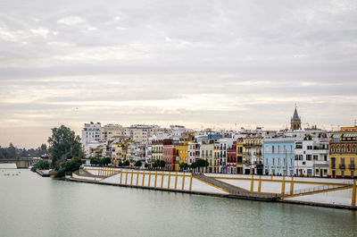 River by cityscape against sky