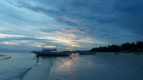 Boat sailing in sea against sky during sunset